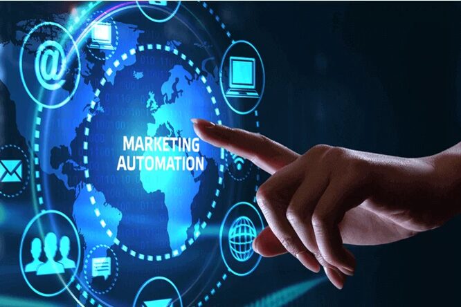 A person's finger is pointing at a digital globe with the text "MARKETING AUTOMATION" in the center. The globe is surrounded by a network of circles containing icons that represent different aspects of digital marketing, such as email, social media, and data analytics